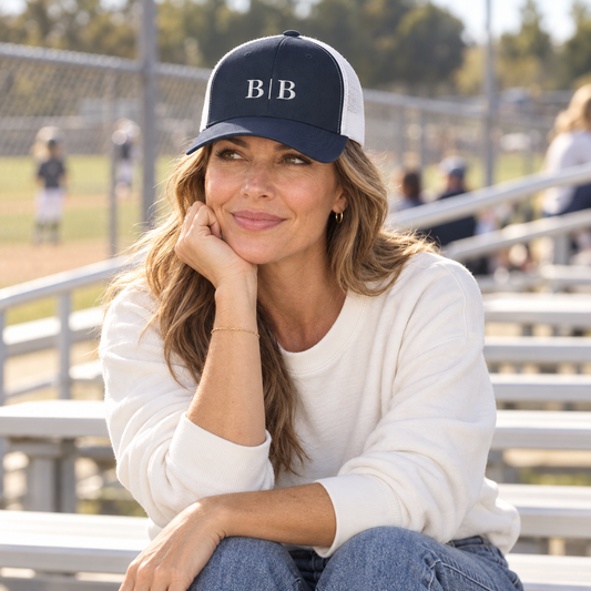 Woman wearing the B | B navy trucker hat at outdoor sports bleachers