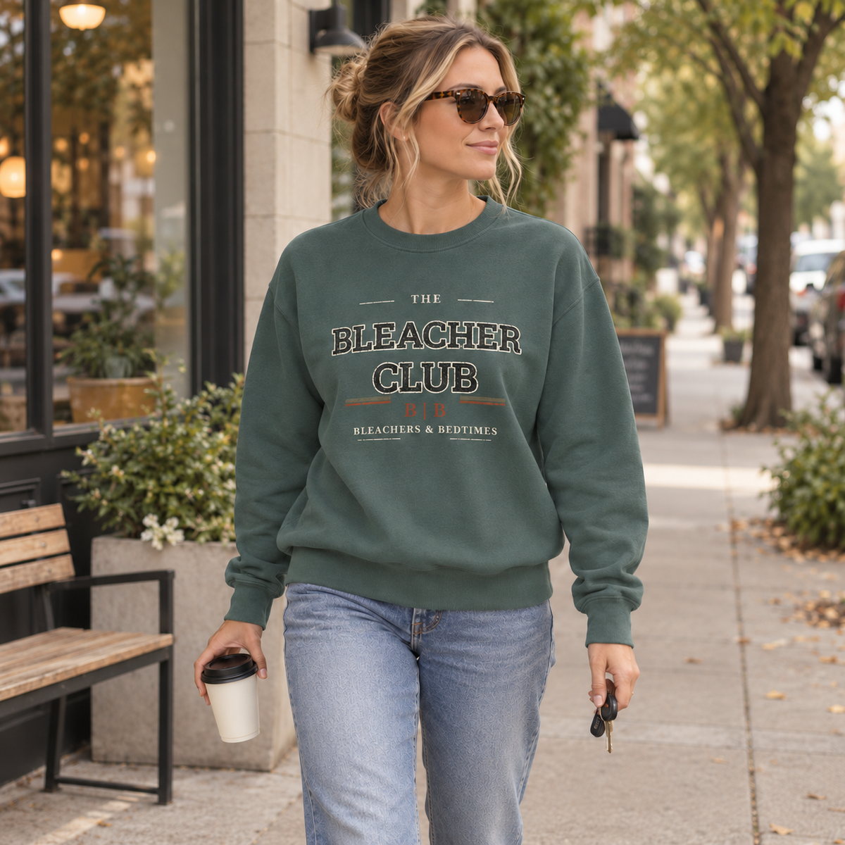 Woman wearing The Bleacher Club Blue Spruce crewneck on a neighborhood coffee run